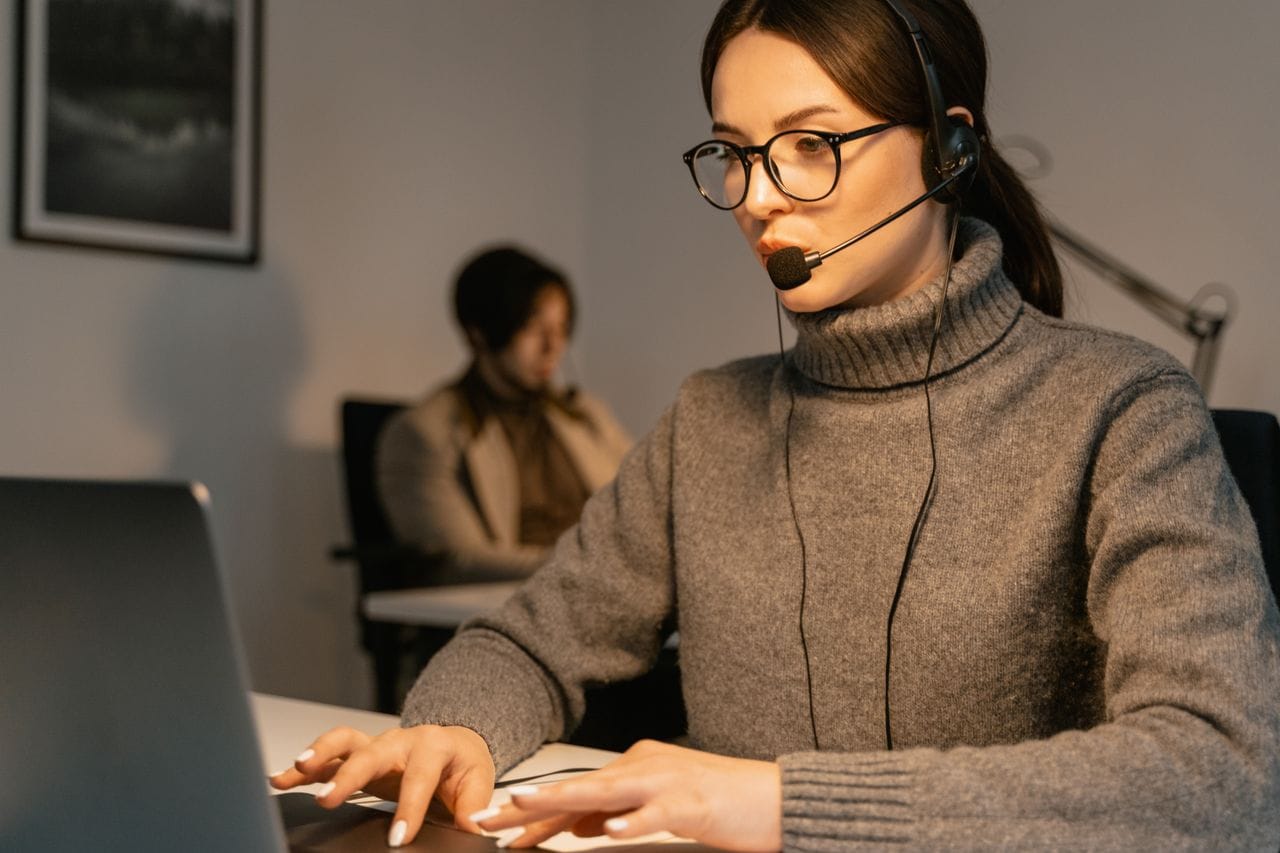 Professional woman wearing headset working in customer support, focused on her tasks.